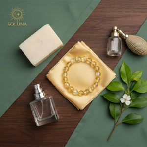 Hình ảnh minh họa cách bảo quản Vòng Thạch Anh Tóc Vàng SOLUNA, cho thấy vòng đá được đặt gần nước hoa và xà phòng, nhắc nhở tránh tiếp xúc với hóa chất để giữ độ bóng vĩnh cửu.